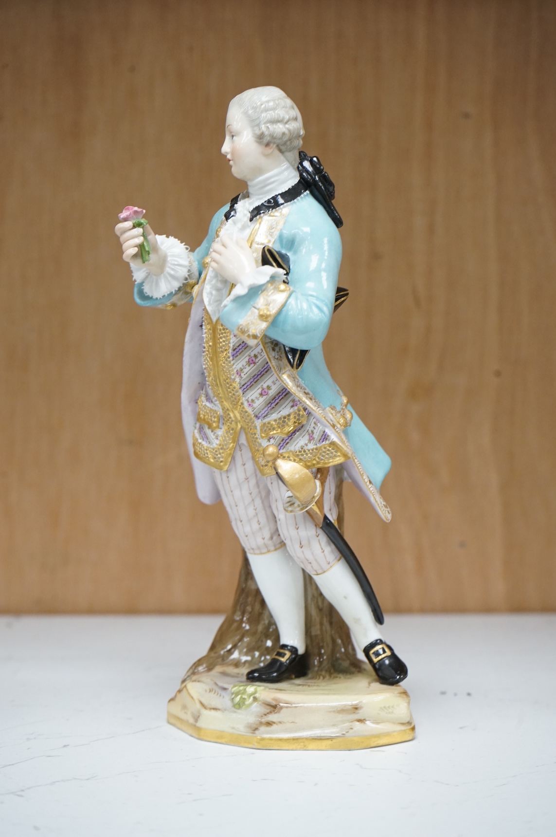 A Meissen figure of a gentleman holding a rose, 19th century, incised model number A58, 19cm high